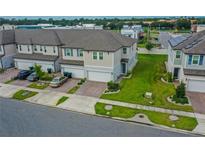 Aerial view of townhouses with landscaped yards and parking at 15259 Willow Arbor Cir, Orlando, FL 32824