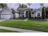 Two story home with attached garage and manicured lawn at 8208 Vineland Oaks Blvd, Orlando, FL 32835