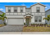 Two story home with gray and white siding, gray roof, and a two car garage at 2210 Lelani Cir, Davenport, FL 33897