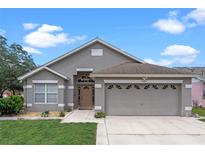 Two-story house with a gray exterior and two-car garage at 7749 Water Oak Ct, Kissimmee, FL 34747