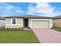 House exterior featuring a two-car garage and well-maintained landscaping at 3174 Viceroy Ct, Poinciana, FL 34759