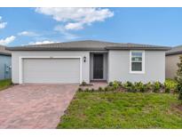 One-story home with gray exterior and brick paver driveway at 3162 Viceroy Ct, Poinciana, FL 34759