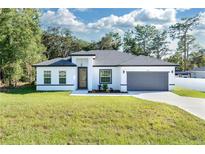 Modern, single story home with a gray garage door and manicured lawn at 526 Marion Oaks Trl, Ocala, FL 34473