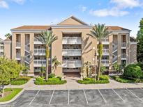 Beige three-story building with balconies and palm trees at 7651 Whisper Way # 401, Reunion, FL 34747