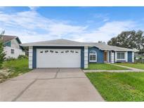 Cute blue house with white garage door and well-maintained lawn at 1115 Marni Ridge Ct, Kissimmee, FL 34747