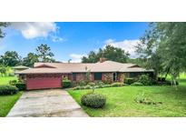 Brick ranch house with attached garage and yard at 4711 County Road 134, Wildwood, FL 34785