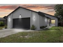 Modern home with a white brick facade and a dark gray garage door at 10544 Wyndcliff Dr, Orlando, FL 32817