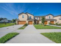 Tan two-story townhome with a double garage at 1714 Wynford Cir, Tavares, FL 32778