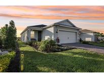 One-story home with gray exterior, white garage door, and landscaping at 2587 Cliff Way, Saint Cloud, FL 34771