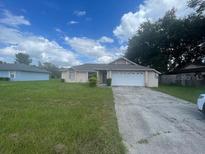 Single-story house with a two-car garage and spacious lawn at 2391 Moonstone Ave, Deltona, FL 32738