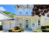 Two-story light blue home with a front porch and two-car garage at 1013 Maiden Ter, Celebration, FL 34747