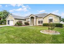 Single-story house with a large front yard, two-car garage, and manicured landscaping at 3211 Bayview Ln, Saint Cloud, FL 34772