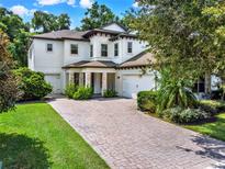 Two-story house with a white exterior, paver driveway, and landscaped yard at 808 Sherbourne Cir, Lake Mary, FL 32746