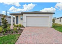 Single story home with a brick driveway and landscaping at 3653 Portsmouth Ln, Haines City, FL 33844