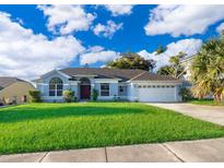 Single story home with a two car garage and large front yard at 7304 High Lake Dr, Orlando, FL 32818