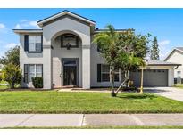 Two story house with gray exterior and a landscaped yard at 11656 Ashridge Pl, Orlando, FL 32824