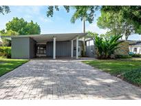 Mid-century modern home with a brick driveway and lush landscaping at 2148 Chippewa Trl, Maitland, FL 32751