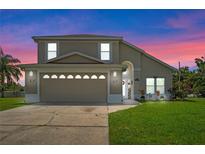 Two-story house with beige exterior and double garage at 2713 Chatham Cir, Kissimmee, FL 34746