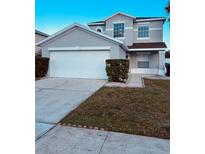 Two-story house with a double garage and well-manicured landscaping at 1347 Heather Lake Dr, Orlando, FL 32824