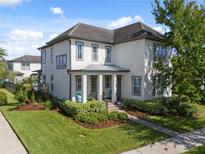 Two-story Craftsman home with gray accents and landscaped yard at 13875 Sachs Ave, Orlando, FL 32827