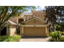 Tan two-story townhome with a two-car garage at 6316 Miramonte Dr # 106, Orlando, FL 32835