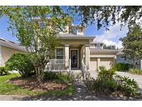 Two-story house with front porch, two-car garage, and landscaping at 8039 Northlake Pkwy, Orlando, FL 32827