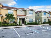 Townhouse exterior, two-story, light green and yellow, with parking at 8967 California Palm Rd, Kissimmee, FL 34747