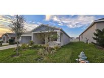 Single-story home with gray siding, landscaping, and a two-car garage at 1007 Theodore St, Davenport, FL 33837