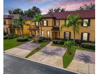 Two-story townhome with brick paver driveway and lush landscaping at 319 Verona Ave, Davenport, FL 33897