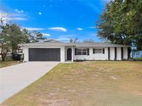 Newly renovated home with a modern facade and spacious driveway at 5400 Fox Briar Trl, Orlando, FL 32808