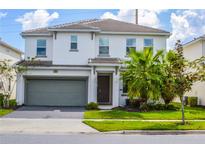 Two-story house with gray garage door and palm trees at 2621 Calistoga Ave, Kissimmee, FL 34741