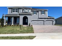 Two story house with gray siding, three car garage and manicured lawn at 3295 Roseville Dr, Apopka, FL 32712
