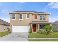 Two-story house with a two-car garage and red door at 1139 August Sky Dr, Deltona, FL 32738