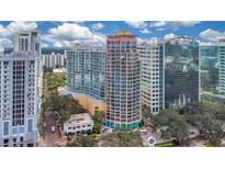 Aerial view of a high-rise building in the city with surrounding buildings and lake at 322 E Central Blvd # 1214, Orlando, FL 32801