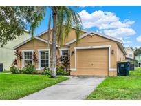Tan house with a two-car garage and nicely landscaped front yard at 188 Ridgemont Ct, Davenport, FL 33896