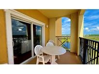 Balcony with table and chairs overlooking a lake at 8101 Resort Village Dr, Orlando, FL 32821