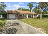 Brick ranch home with carport and lawn at 1421 Avenue G Ne, Winter Haven, FL 33881