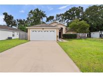 Tan house with attached garage and driveway at 9920 4Th Ave, Orlando, FL 32824