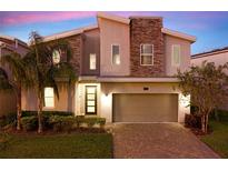 Modern two-story house with stone accents and landscaped yard at 453 Ocean Course Ave, Champions Gate, FL 33896