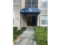 Building entrance with stairs and landscaping at 3000 Laurel Park Ln # 104, Kissimmee, FL 34741