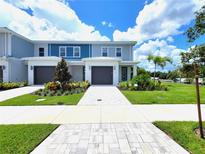 Two-story townhome with landscaped front yard and driveway at 7924 Spectrum Dr, Kissimmee, FL 34747