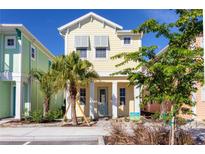 Two-story light yellow house with teal door and shutters at 3074 Key Lime Loop, Kissimmee, FL 34747