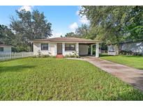 Charming bungalow with a carport, well-maintained lawn, and white picket fence at 507 Francis Blvd, Lakeland, FL 33801