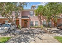 Three story light pink townhome with two parking spaces at 2332 Caravelle Cir, Kissimmee, FL 34746