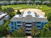 Multi-story building exterior with brick and blue accents, near a golf course at 1100 Sunset View Cir # 203, Reunion, FL 34747