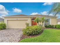 One-story home with a beige exterior, two-car garage and landscaped yard at 503 Balmoral Dr, Davenport, FL 33896