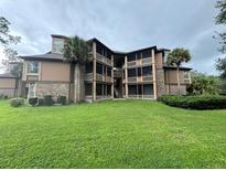Exterior view of a multi-story condo building with lush landscaping at 470 S Pin Oak Pl # 204, Longwood, FL 32779