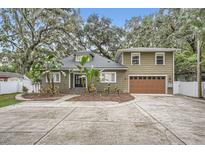 Two-story house with a large driveway and landscaped front yard at 734 S Mills Ave, Orlando, FL 32801