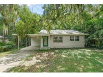 Cozy one-story house with a covered carport and green door at 104 E Mcclendon St, Lady Lake, FL 32159