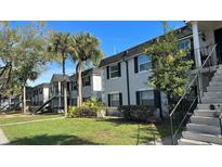 Exterior view of an apartment building with lush landscaping at 7622 Forest City Rd # E, Orlando, FL 32810
